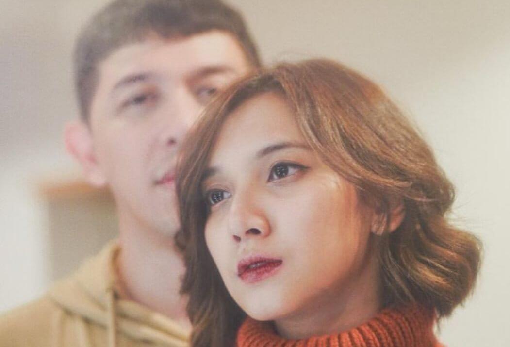 Sheila berpose di depan Donne dengan turtleneck warna oranye tua